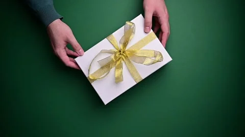 Person with gift box, present with golden ribbon. Top view of hands rotating Stock Footage 206504918