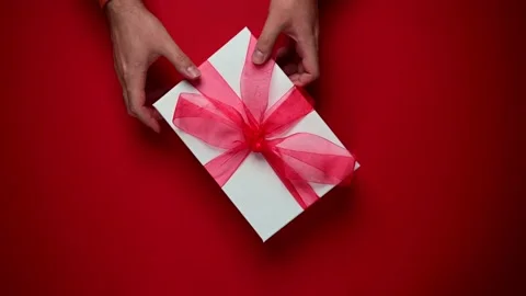 Person with gift box, present with red ribbon. Top view of hands rotating Stock Footage 201977710