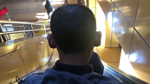 A person is going down an escalator, the video is taken from behind so no face Stock Footage 306758701