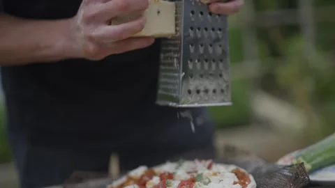 A person is grating cheese on a grater Stock Footage 297843693