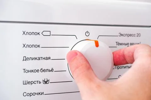 Person hand choosing cycle program on washing machine. Stock-Fotos