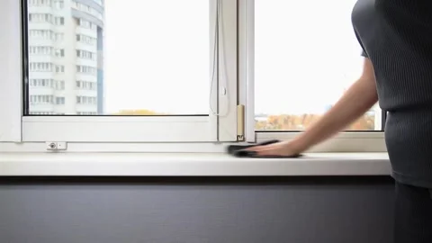Person hand cleans windowsill of window in apartment room with dark microfiber Stock Footage 329621965