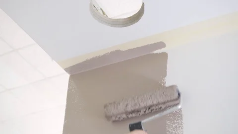 Person hand colours white wall in brown with roller brush Video stock 124892575