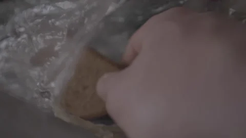 Person hand grabs piece of bread with mildew from package Stock Footage 240572758