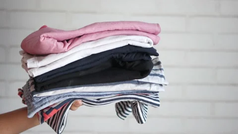 Person hand hold a stack of clothes Stock Footage 162169300