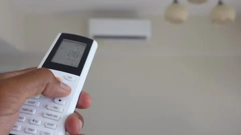 Person hand holding remote control to adjust air conditioning temperature i.. Stock Footage 332745014