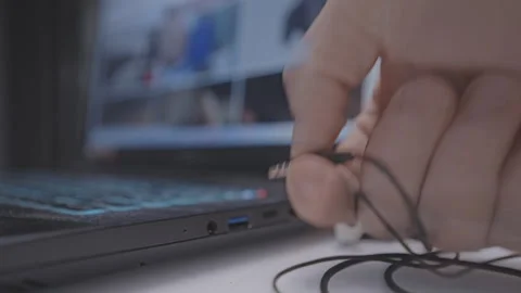 Person hand pull out headset cord from stereo jack music port in laptop Stock Footage 258106842