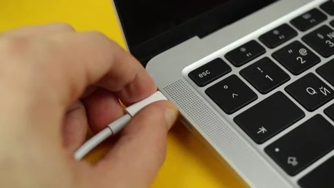 Person hand pull out or extract a USB-C cable charger from computer or laptop Stock Footage 170153998
