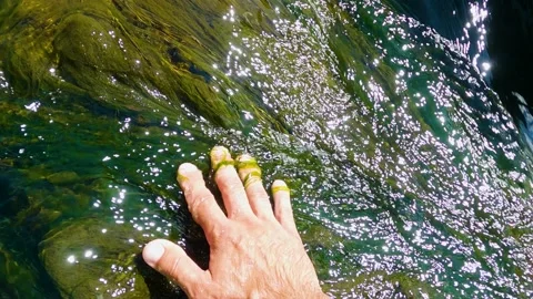 Person hand put in the flowing river and is captivated by the water 库存影片 199191712