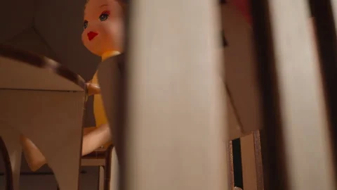 Person hand puts tiny chair at table with dolly in toy house Video stock 160210943