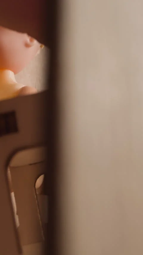 Person hand puts tiny chair at table with dolly in toy house Video stock 317805143