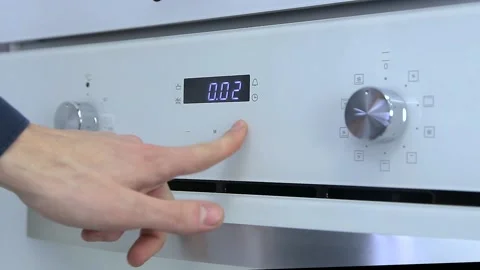 Person hand touching sensor button on electric oven in kitchen. Stock Footage 188557965