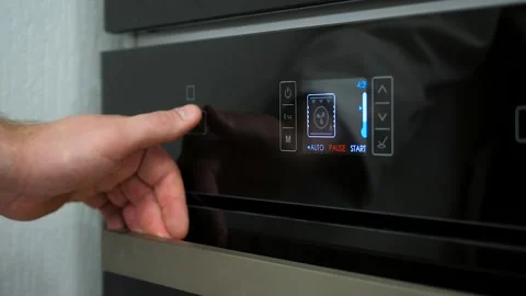 Person hand touching sensor button on electric oven in kitchen. Stock Footage 188565468
