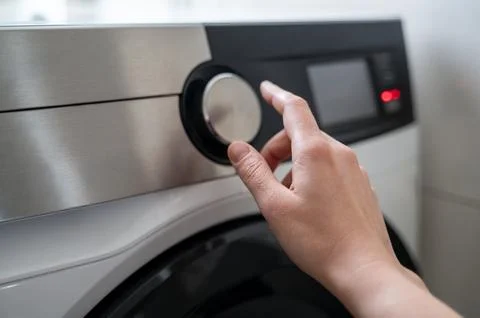 Person hand using handle on washing machine Stock Photos