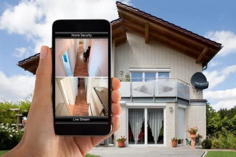 Person Hand Using Home Security System On Mobile Phone Foto stock