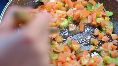 Person hand using kitchen spatula for stirring chopped fresh vegetables in Stock Footage 250014421