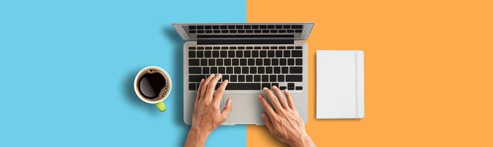Person hand using laptop computer from above with coffee and smartphone on .. Stock Photos