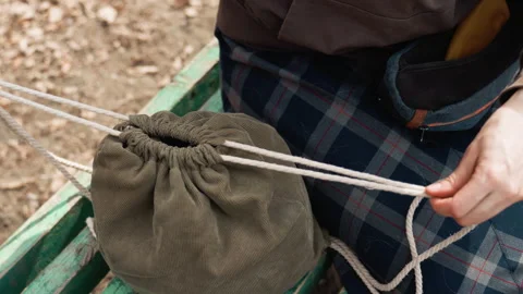 Person Handling Scissors and Placing Them in Olive Green Drawstring Bag with Video stock 345845528