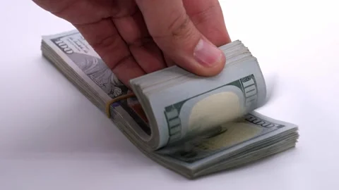 Person handling a stack of hundred-dollar bills in slow motion Stock Footage 318948111