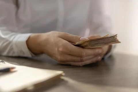 Person hands holding a large stack of money, a thick bundle of cash bills s.. Stock Photos