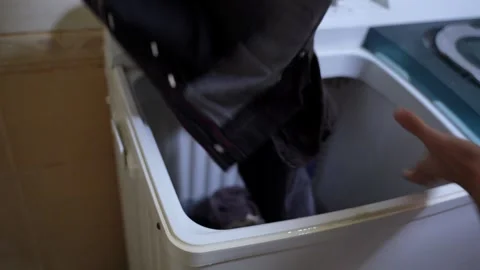 Person Hands Loading Dark Denim Jeans into Top-Loading Washing Machine 스톡 동영상 322716875