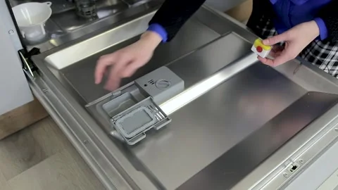 Person hands loads detergent "all in one" into the dishwasher Stock Footage 167797248