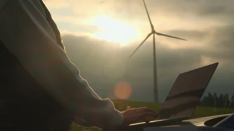 Person hands make notes of functioning wind turbine on field Video stock 203560334