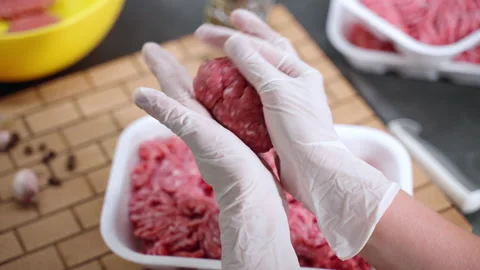 Person hands making beef meatballs, pressing and rotating between hands palms Stock Footage 211404074