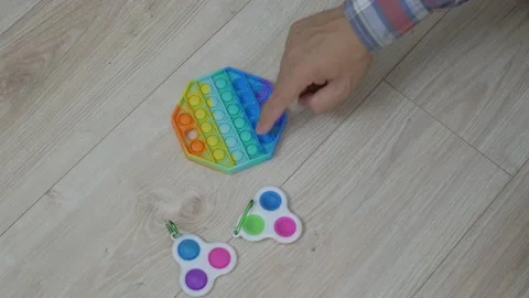Person hands presses bubbles on modern silicone toy pop it. Stock Footage 159345378