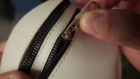 Person Hands Pulling Metal Zipper Slider on Small White Leather Bag Video stock 338092618