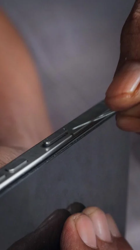 Person hands using an ejector tool to open the SIM card tray slot Stock Footage 348910213