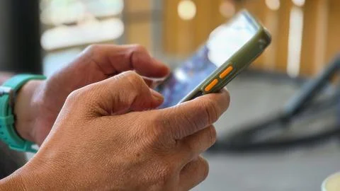 Person Hands Using Smartphone with Protective Case and Smartwatch Stock Photos