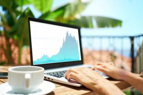 Person hands working on laptop computer with financial graphs, stock charts on Stock Photos