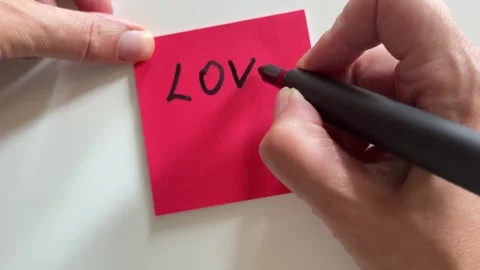 Person handwriting a romantic message on paper for Valentine day concept Stock Footage 338186445