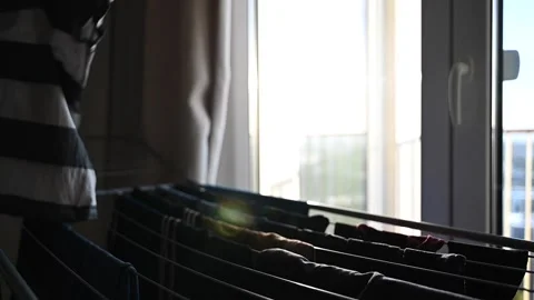 Person hanging clothes to drying rack Stock Footage 233591849