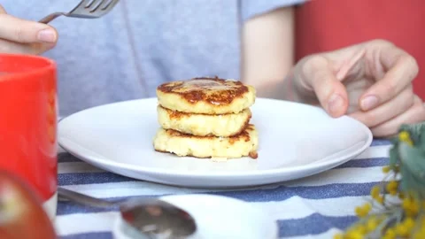 Person having rustic breakfast of apple pancakes and honey with fork	 Video stock 134027900