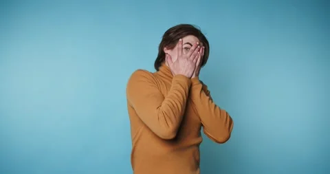 Person hides face in four frames showing a range of reactions in front of a.. Video stock 328249971