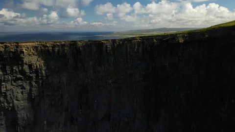 Person hiking the Cliffs of Moher Atlantic walk along clifftop, aerial Stock Footage