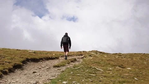 Person hiking on the mountain with clouds Stock Footage 297792449