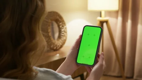 Person hold mobile cell phone with green screen and zoom in photo at office. Vidéo 321346708