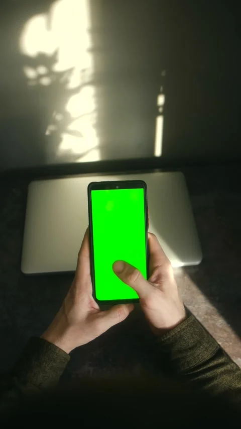 Person holding and using smartphone with green screen mockup 動画素材 337827339