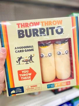 A person holding a box of Throw Throw Burrito dodgeball card game on a stor.. 库存照片