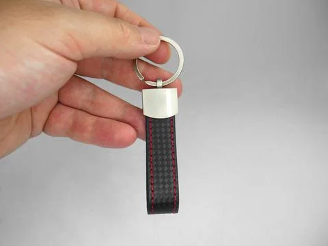 A person holding a car keychain with a strap Stock Photos