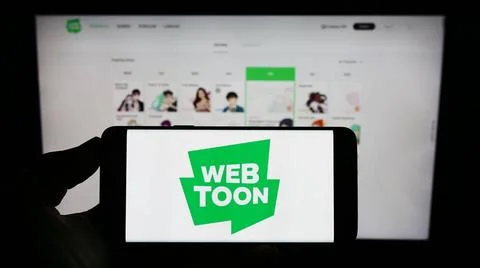 Person holding cellphone with logo of digital comic company WEBTOON Entert... Foto stock
