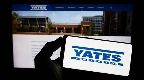  Person holding cellphone with logo of US building company Yates Construct... Stock Photos