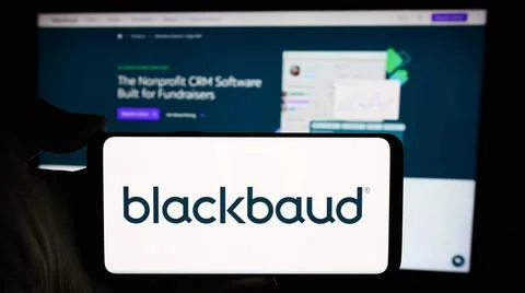 Person holding cellphone with logo of US software company Blackbaud Inc. i... Foto stock