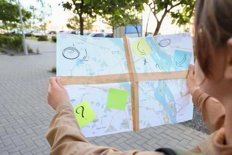 Person holding a city map with notes outdoors Stock Photos