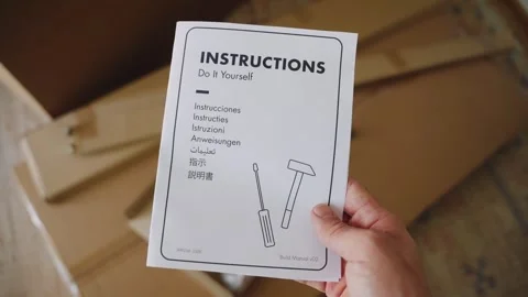 Person holding a do it yourself furniture instruction manual Video stock 347030173