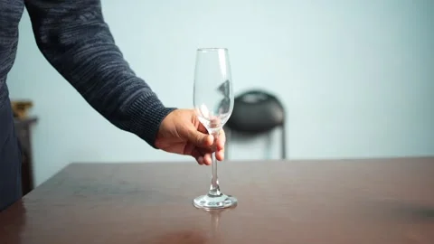Person Holding Empty Glass on Table Stock Footage 339562809
