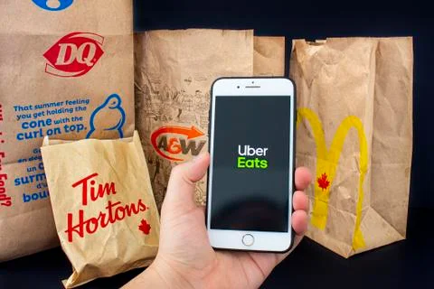 A person holding an iPhone Plus with the Uber Eats application open Stock Photos